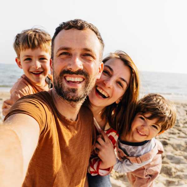 Smiling family taking a selfie at the beach