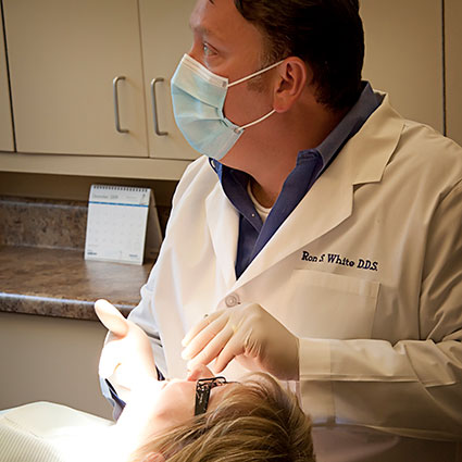Dr. White cleaning a patient's teeth