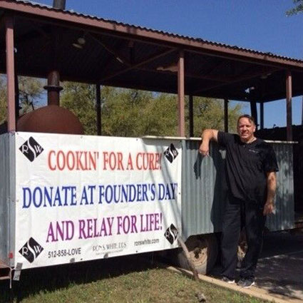 Dr. Ron standing in front of a sign at Founder's Day event